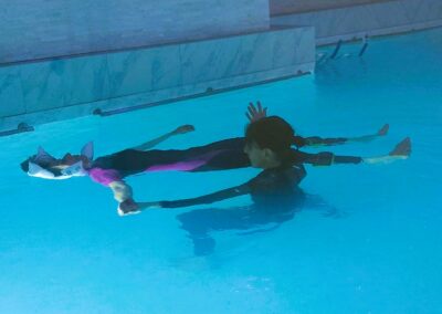 Femme en relaxation aquatique dans une piscine chauffée, bras écartés, symbole du bien-être et de la sophrologie à Bastia