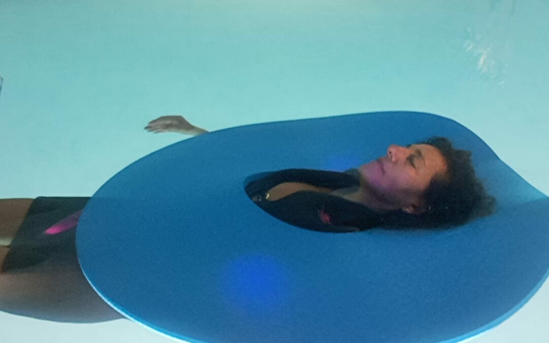 Femme relaxée flottant dans l'eau bleue et accessoires de massage terre pour atelier sophrologie aquatique Bastia